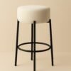 Tabouret contemporain avec assise bouclée écrue et piètement en métal noir.